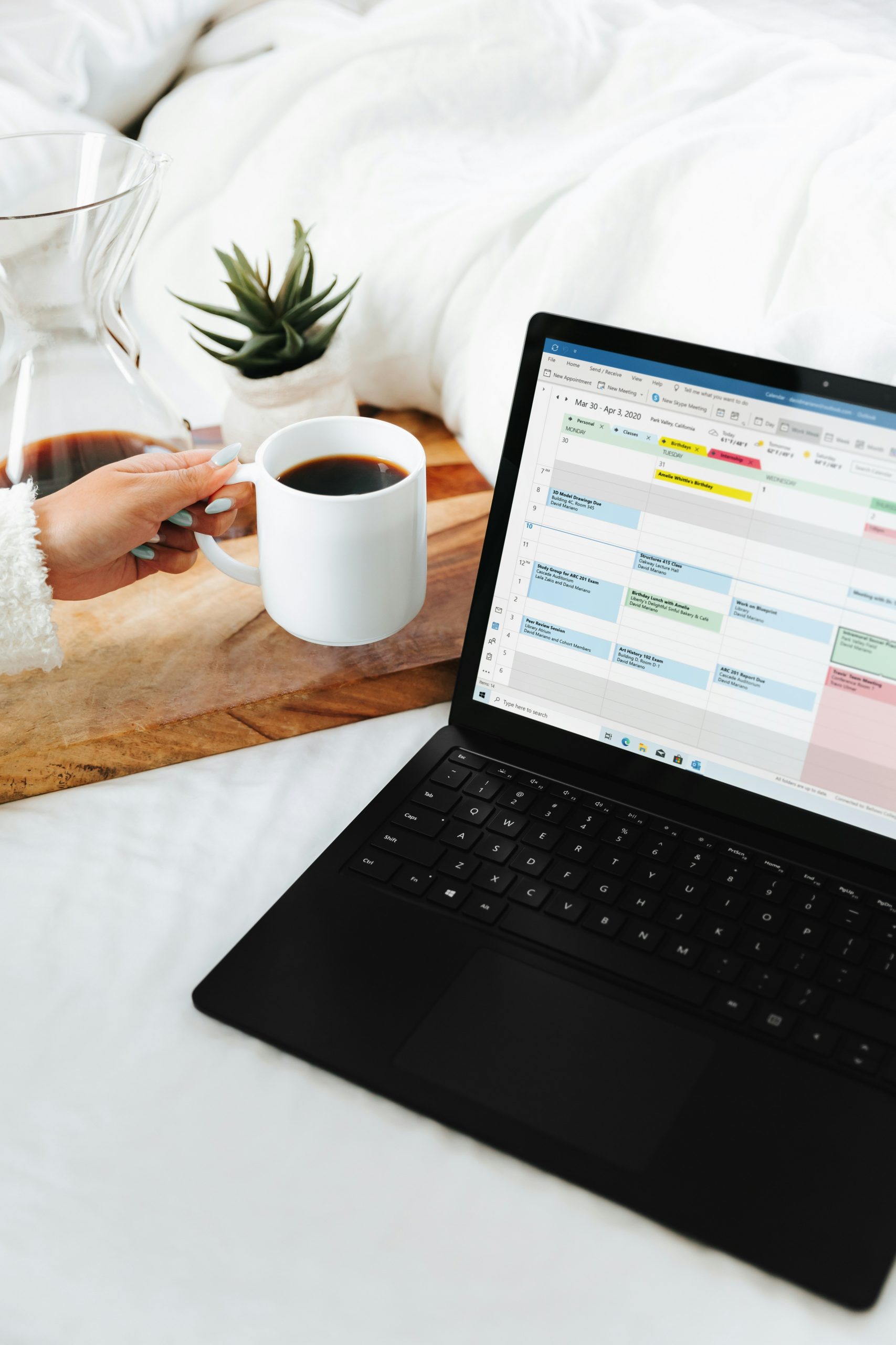 Digital marketer working on a laptop with notebook and coffee cup in a clean workspace